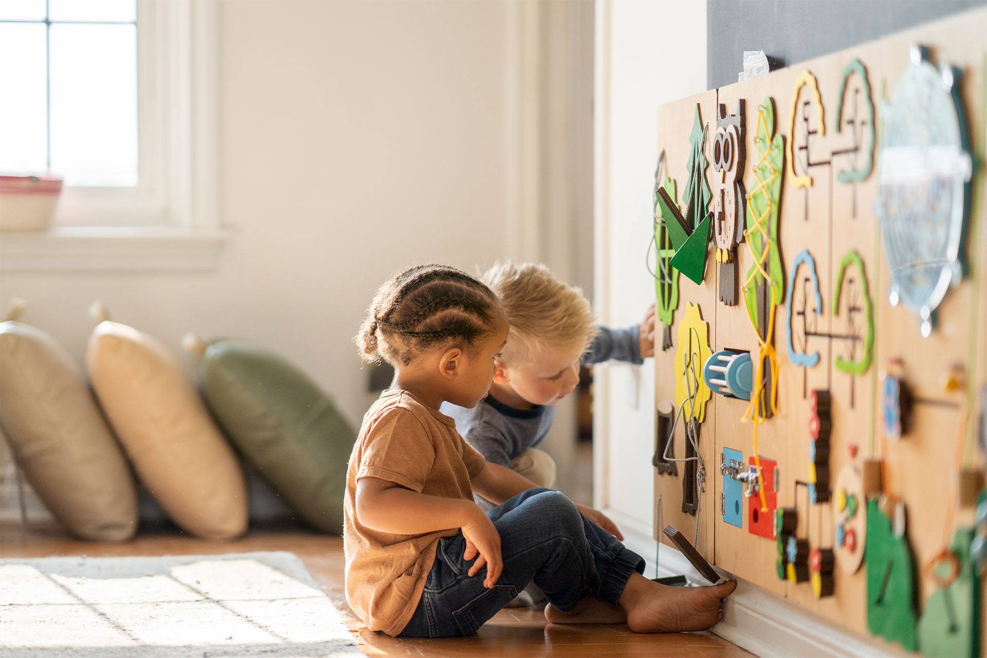 Zwei Kinder sitzen vor Spielewand